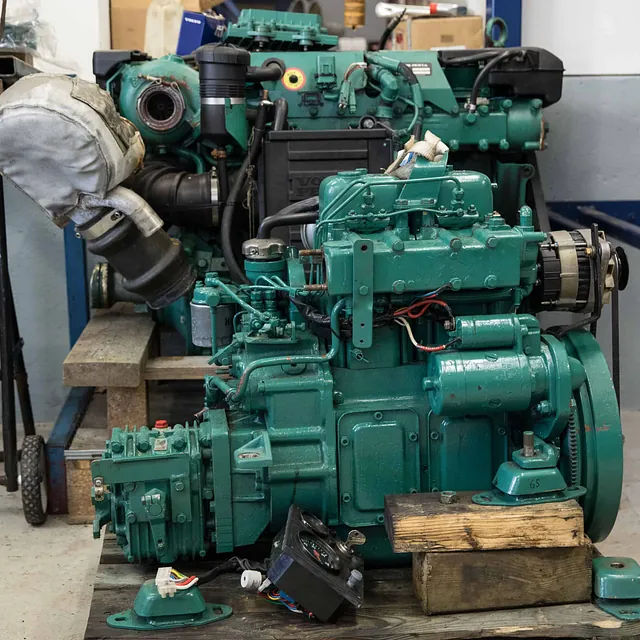Stor grønn industriell motor med slanger og elektriske komponenter på en plattform